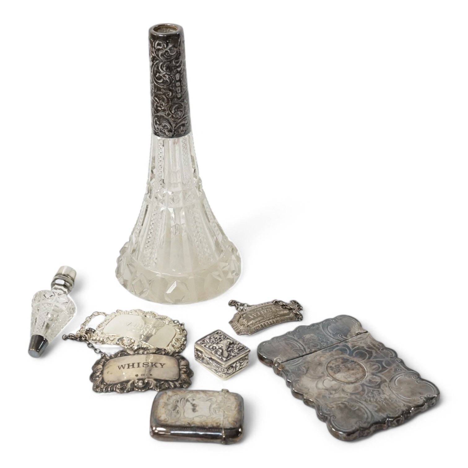 A small group of collectable silver including a Victorian engraved card case, Hilliard & Thomason, Birmingham, 1856, 10cm, three modern wine labels, a vesta case, a 925 pill box and an Edwardian mounted glass scent bottl